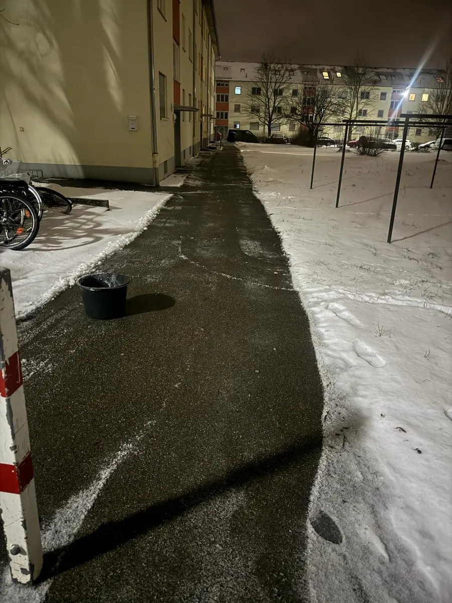 Geräumter Gehweg zwischen schneebedeckten Flächen